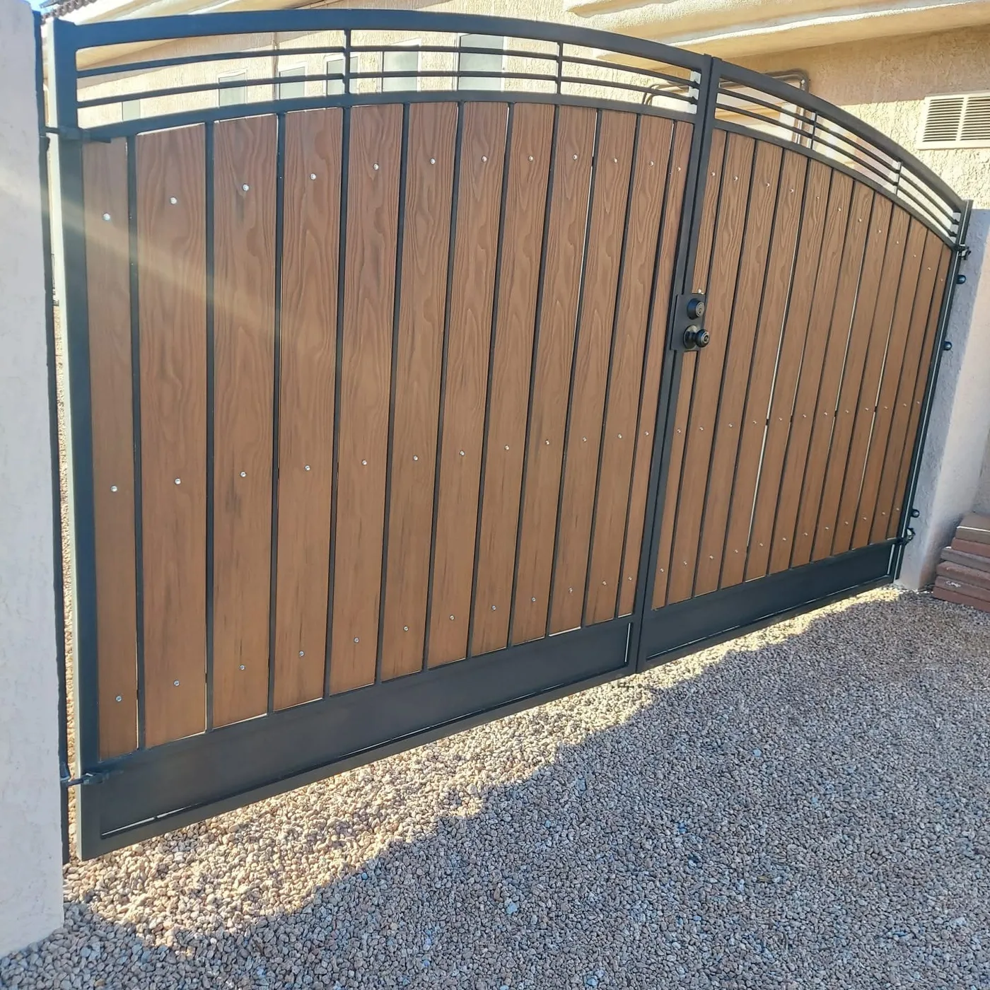 Arched driveway gate in wood and black iron we fabricated