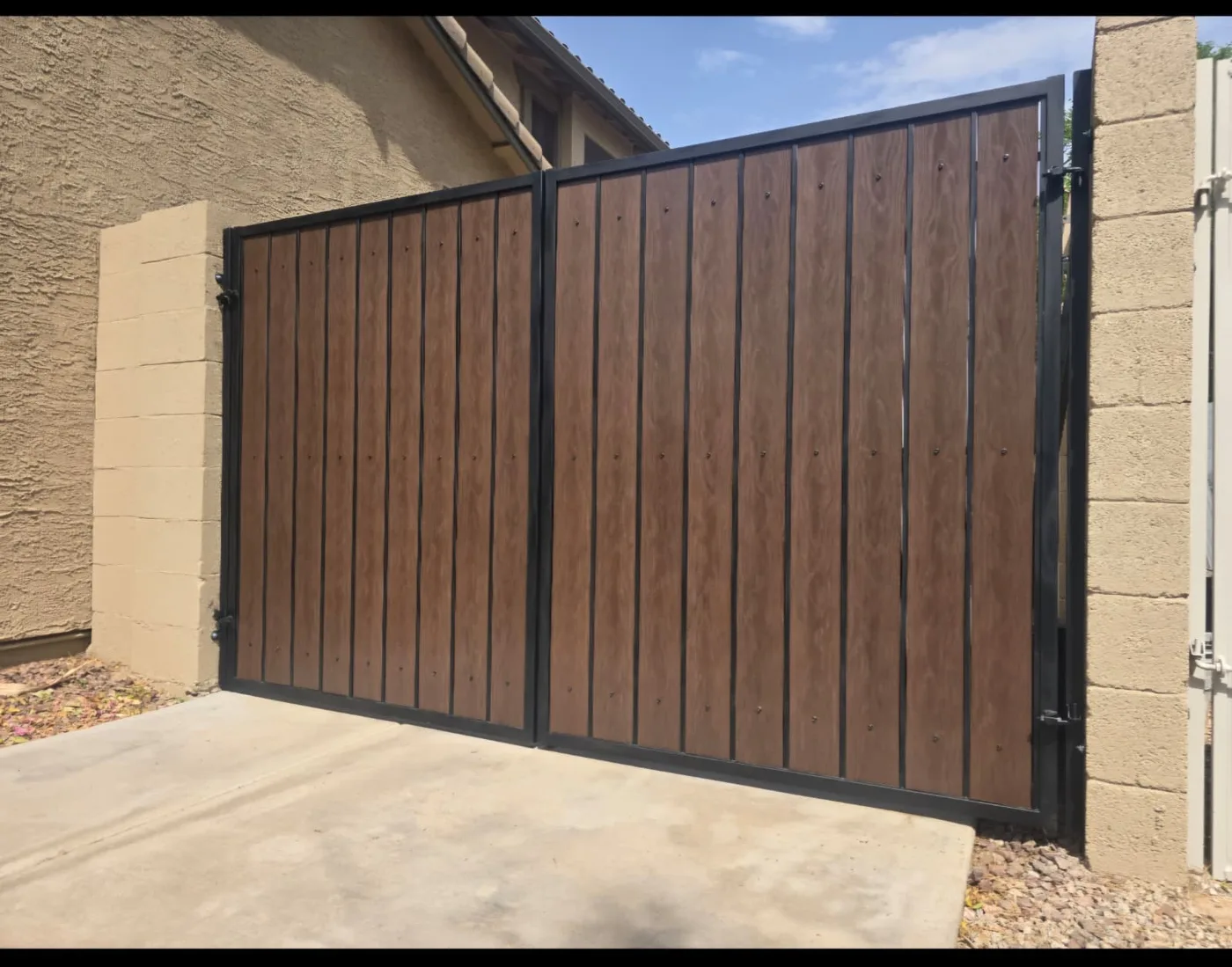 Wood-slat driveway gate framed in steel